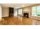 Living room with hardwood floors, fireplace, built in bookcase, and view to backyard at 9550 Copley Dr, Indianapolis, IN 46260