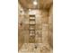 Shower with travertine tile, recessed shelving, and updated showerhead at 9550 Copley Dr, Indianapolis, IN 46260