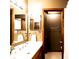 Bathroom featuring a wood vanity with double mirrors and doorway into shower room at 1010 Lakewood N Dr, Brownsburg, IN 46112