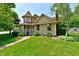 Charming two-story home with a turret, lush green lawn, and a welcoming brick pathway at 1010 Lakewood N Dr, Brownsburg, IN 46112