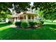 Charming home exterior with well-manicured lawn, mature trees, and an inviting front porch, creating a welcoming curb appeal at 1010 Lakewood N Dr, Brownsburg, IN 46112