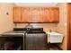 Clean laundry room featuring wood cabinets, stainless steel washer/dryer and laundry sink at 1010 Lakewood N Dr, Brownsburg, IN 46112
