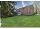 Exterior shot of a two-story brick house with a green lawn and large evergreen trees at 10245 Briar Creek Ln, Carmel, IN 46033