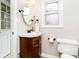 Cozy bathroom with wood vanity, small window, and white toilet at 10245 Briar Creek Ln, Carmel, IN 46033