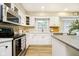 Modern kitchen with white cabinets, stainless steel appliances, and hardwood floors at 10245 Briar Creek Ln, Carmel, IN 46033