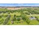 Aerial view of the home surrounded by mature trees, landscaping, and open fields at 10444 N State Road 9, Fountaintown, IN 46130