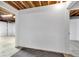Wide view of an unfinished basement featuring a white wall, concrete floor, and open doorframe at 10444 N State Road 9, Fountaintown, IN 46130