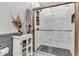 Modern bathroom featuring a glass-enclosed shower with decorative herringbone tile and dark river rock flooring at 10444 N State Road 9, Fountaintown, IN 46130