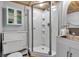 Updated bathroom featuring a glass shower with white tile, storage cabinet, and modern fixtures at 10444 N State Road 9, Fountaintown, IN 46130