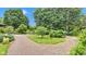 Gravel driveway leading to a home nestled among beautiful landscaping and mature trees at 10444 N State Road 9, Fountaintown, IN 46130