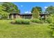 Charming stone home featuring a well-manicured lawn and beautiful landscaping at 10444 N State Road 9, Fountaintown, IN 46130