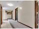 Hallway with a mix of tiled and carpeted flooring, complemented by natural wood trim and doors at 10444 N State Road 9, Fountaintown, IN 46130