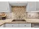 Up close view of kitchen sink, granite countertop, custom backsplash, and white cabinetry at 10444 N State Road 9, Fountaintown, IN 46130