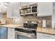 Updated kitchen appliances with stone backsplash, granite counters, and stainless steel microwave at 10444 N State Road 9, Fountaintown, IN 46130