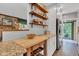 Open kitchen layout with wood shelving, stainless steel refrigerator, and granite counters at 10444 N State Road 9, Fountaintown, IN 46130