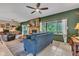 Spacious living room featuring a stone fireplace, ceiling fan, and green accent wall at 10444 N State Road 9, Fountaintown, IN 46130