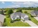 An aerial view of a well-maintained home with a pristine lawn, landscaping, trees, and a nearby golf course and water feature at 10510 Inverness Ct, Fishers, IN 46037