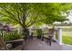 A relaxing outdoor deck with Adirondack chairs and potted plants overlooking the manicured lawn and landscaping at 10510 Inverness Ct, Fishers, IN 46037