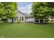 An expansive green backyard and deck area with a well-manicured lawn, landscaping, and a modern deck with chairs at 10510 Inverness Ct, Fishers, IN 46037