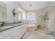 Luxurious bathroom featuring a soaking tub, glass enclosed shower, dual sinks, and plenty of light at 10510 Inverness Ct, Fishers, IN 46037