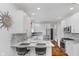 Stylish kitchen with white cabinetry, marble countertops, stainless steel appliances, and wood floors at 10510 Inverness Ct, Fishers, IN 46037