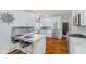 Modern kitchen featuring white cabinets, marble countertops, a breakfast bar, and stainless steel appliances at 10510 Inverness Ct, Fishers, IN 46037