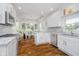 Well-lit kitchen with white cabinets, marble backsplash, modern appliances, and seamless flow to dining area at 10510 Inverness Ct, Fishers, IN 46037