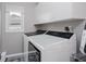 Functional laundry room with a washer, dryer, storage cabinets, and a window at 10510 Inverness Ct, Fishers, IN 46037