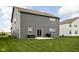 Backyard featuring a well-maintained lawn, patio with outdoor seating, and gray siding home exterior at 11588 Brooks Farm Blvd, Noblesville, IN 46060