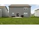 Backyard featuring a well-maintained lawn, patio with outdoor seating, and gray siding home exterior at 11588 Brooks Farm Blvd, Noblesville, IN 46060