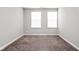 Empty bedroom with neutral carpet and two windows, offering natural light and comfortable space at 11588 Brooks Farm Blvd, Noblesville, IN 46060