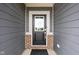 Stylish black front door framed by gray siding and brick accents for a welcoming entrance at 11588 Brooks Farm Blvd, Noblesville, IN 46060