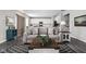 Stylish living room featuring a gray sofa, patterned rug, and an open view into the kitchen at 11588 Brooks Farm Blvd, Noblesville, IN 46060