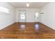 Well-lit living room featuring gleaming hardwood floors, bright windows, and white door at 1311 N Oakland Ave, Indianapolis, IN 46201