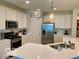 Bright kitchen with stainless steel appliances, white cabinetry and a stone countertop island at 1349 Sunset Blvd, Avon, IN 46123