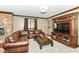 Cozy living room featuring a stone fireplace, large leather sectional, and built-in entertainment center at 13909 Waterway Blvd, Fishers, IN 46040