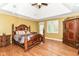 This main bedroom features hardwood floors, a ceiling fan, an armoire, and decorative trim at 13909 Waterway Blvd, Fishers, IN 46040