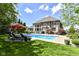 Relaxing backyard pool area featuring lounge chairs, umbrellas, and lush landscaping for outdoor enjoyment at 13909 Waterway Blvd, Fishers, IN 46040