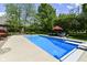 Sparkling in-ground pool with a diving board, surrounded by a concrete patio and lush greenery at 13909 Waterway Blvd, Fishers, IN 46040
