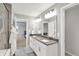 Bright bathroom featuring a double vanity with stone countertop and modern lighting fixtures at 16598 Dominion Dr, Fortville, IN 46040