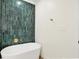 Bathroom boasts a sleek standalone tub accented by distinctive vertically stacked green tile at 16598 Dominion Dr, Fortville, IN 46040