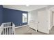 Comfortable Bedroom with blue accent wall, white crib, and lots of natural light at 16598 Dominion Dr, Fortville, IN 46040