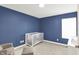 Cozy Bedroom with a blue accent wall, a white crib and a large window at 16598 Dominion Dr, Fortville, IN 46040