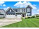 Charming two-story home with lush green lawn, a two-car garage, and beautiful landscaping at 16598 Dominion Dr, Fortville, IN 46040