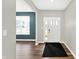 Bright foyer featuring hardwood floors, a white door, and a view into another room at 16598 Dominion Dr, Fortville, IN 46040