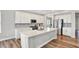 Modern kitchen with stainless steel appliances, white cabinets, an island, and hardwood floors at 16598 Dominion Dr, Fortville, IN 46040
