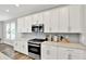 Bright kitchen features white cabinets, stainless steel appliances, and light gray backsplash at 16598 Dominion Dr, Fortville, IN 46040