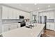 Modern kitchen with stainless appliances, white cabinets, quartz countertop, and hardwood floors at 16598 Dominion Dr, Fortville, IN 46040