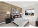 Cozy bedroom with a wood accent wall, stylish furnishings, and a bright window overlooking the outdoors at 1725 Hemlock Cir, Greenfield, IN 46140