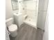 Bathroom featuring a clean shower, modern vanity, toilet, storage cabinet, and gray vinyl flooring at 1801 Bauer Rd, Indianapolis, IN 46218